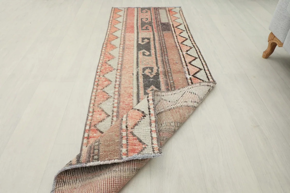 The runner rug partially folded, demonstrating its flexibility and the texture of its wool pile.