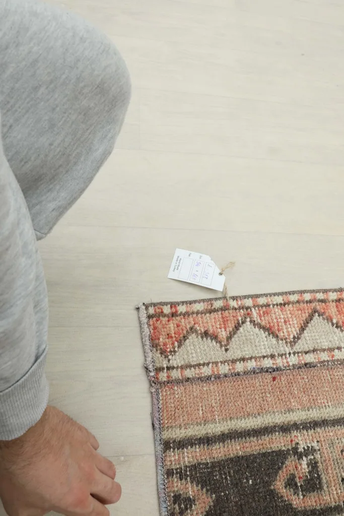 Rug tag visible near the corner of the runner, alongside a person's foot for scale.
