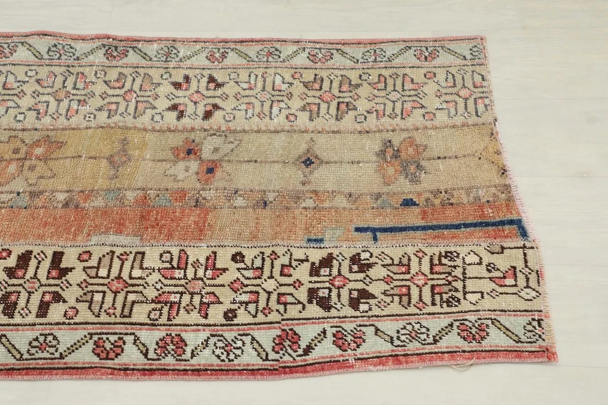 Close-up of the upper section of the rug, highlighting tribal and floral motifs.