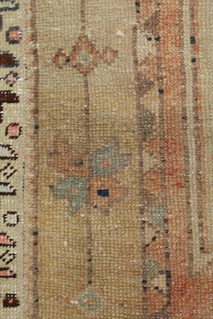 Close-up showing the low wool pile and hand-knotted texture of the rug.
