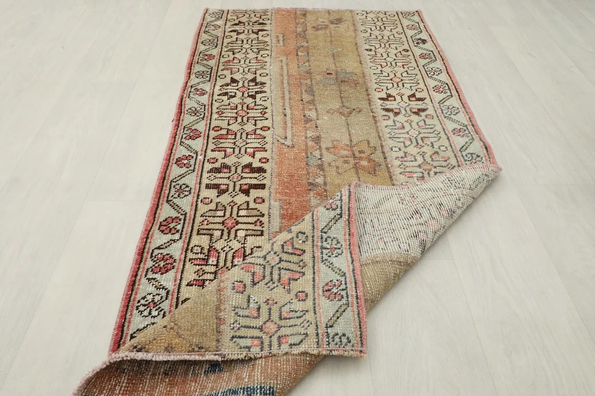 The rug folded back to reveal its thickness and the reverse side of the weave.