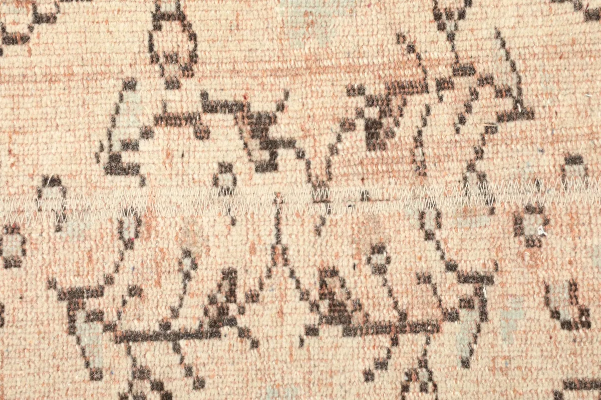 Detailed view of the central geometric and floral motifs, showing the low pile and vintage wear.