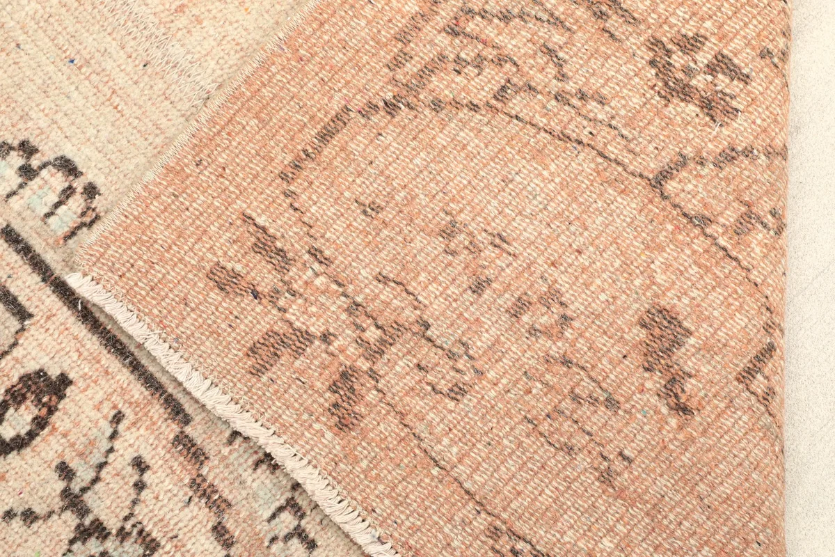 Close-up of the low wool pile and a folded section, revealing the cotton foundation.