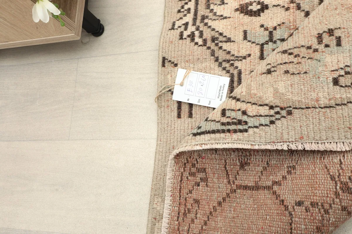 Close-up of the rug's back, revealing the hand-knotted foundation and a tag.