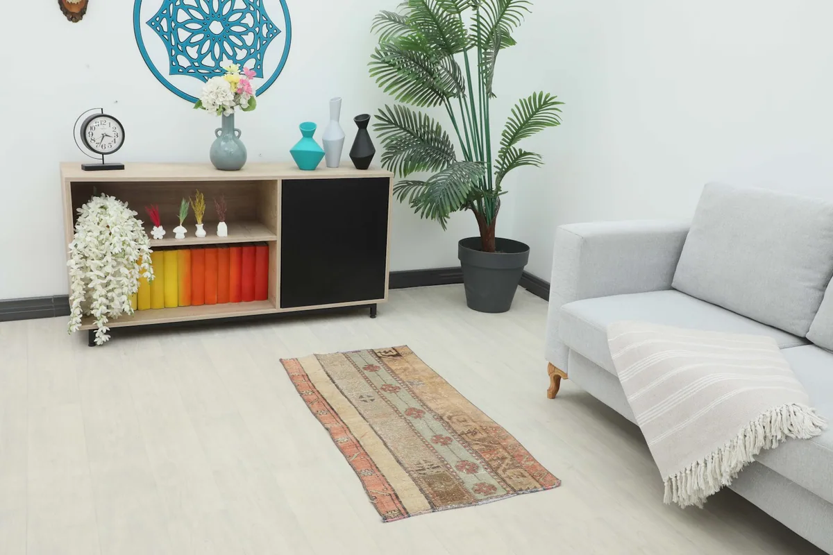 Vintage patchwork rug in a living room setting next to a sofa and cabinet