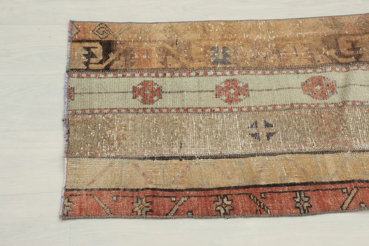 Detailed view of the vintage rug's patterns and colors from one end