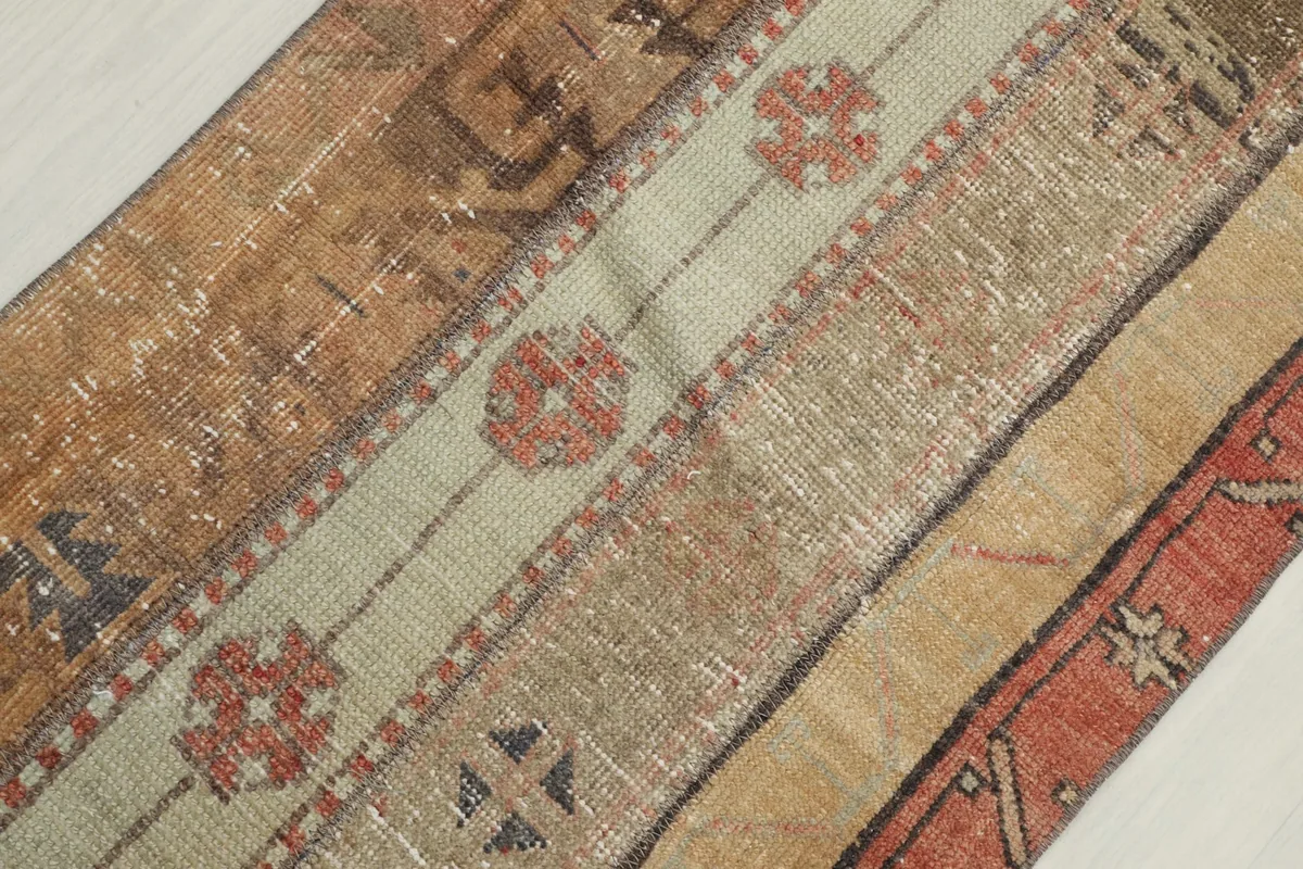 Close-up showing the varied texture and faded colors of the wool pile