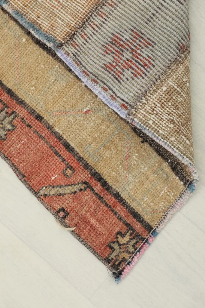 Corner view showing the cotton foundation and reverse side of the hand-knotted rug
