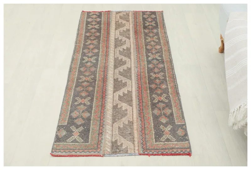 Full top view of the charcoal and beige geometric vintage Anatolian runner rug on a white background.