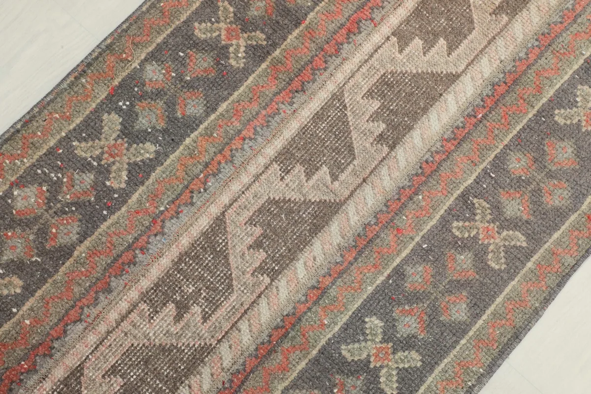 Diagonal close-up view of the rug's surface, revealing the texture and intricate geometric design.