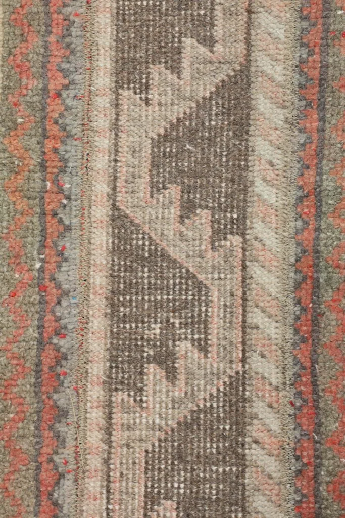 Detailed view of the rug's low wool pile, showing the hand-knotted texture and color blend.