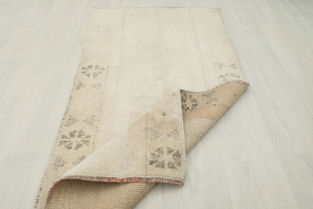 Rug partially folded, displaying the flexibility and the hand-knotted construction from the side