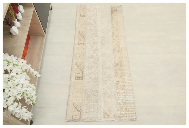 Full top view of the 1'9" x 4'4" beige and tan vintage Anatolian runner rug on a white background.