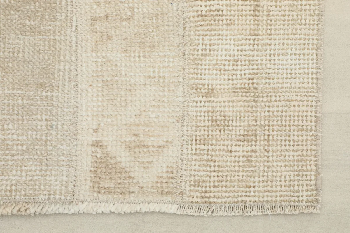 Close-up of the low wool pile and hand-knotted texture, revealing the vintage wear and beige tones.