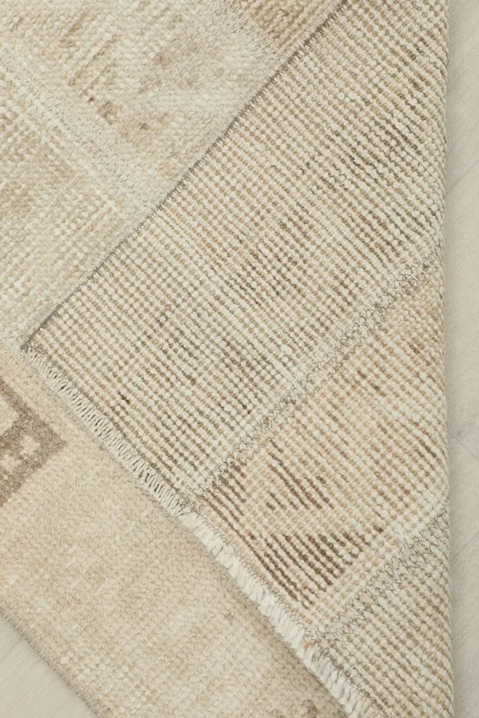 View of the back of the hand-knotted rug, revealing the cotton foundation and construction.