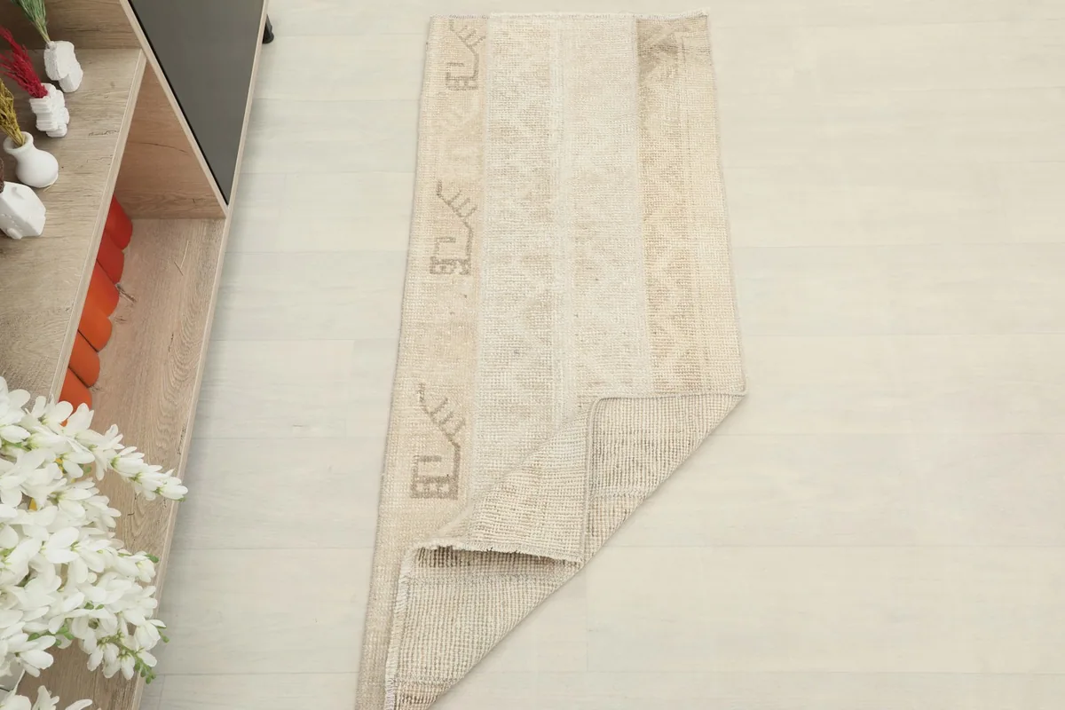 The runner rug partially folded to show its flexibility and thickness in a room setting.
