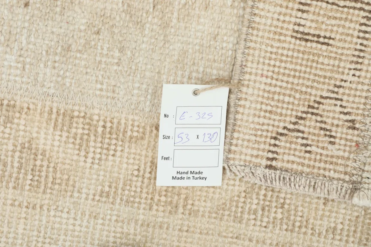 Close-up of the rug with a size tag, confirming the dimensions and hand-made origin.