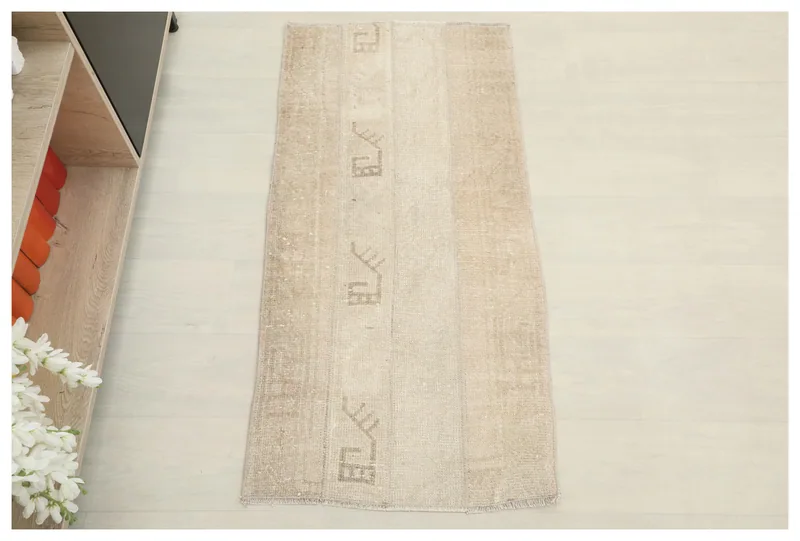 Full overhead view of the beige geometric patchwork rug on a white background