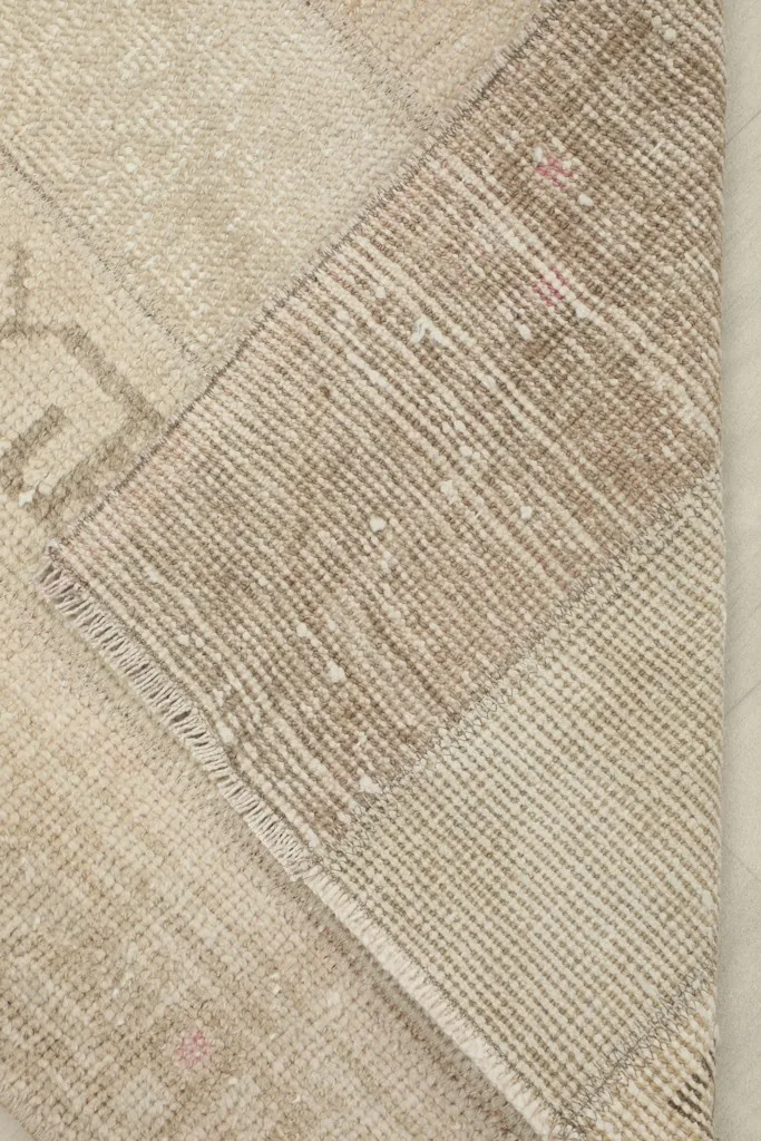 View of the rug's reverse side, showing the cotton foundation and hand-knotting