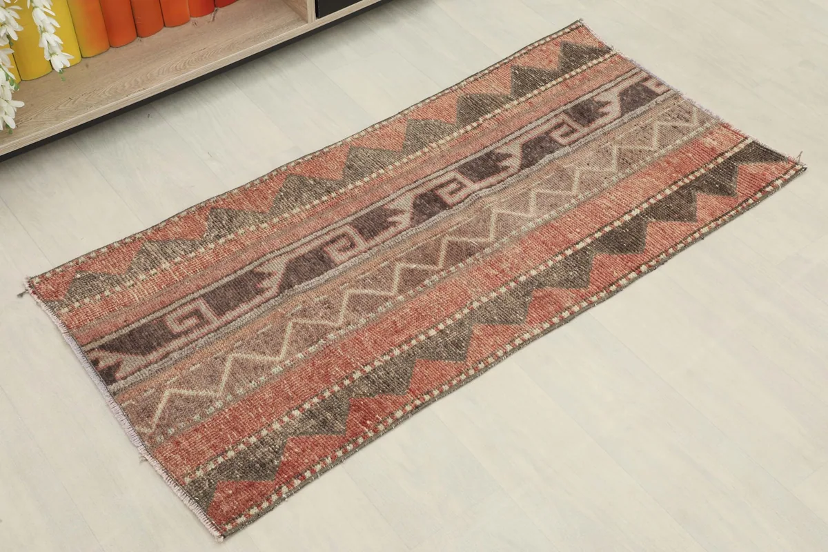 Angled view of the vintage Anatolian rug, highlighting its striped tribal patterns and warm color palette.