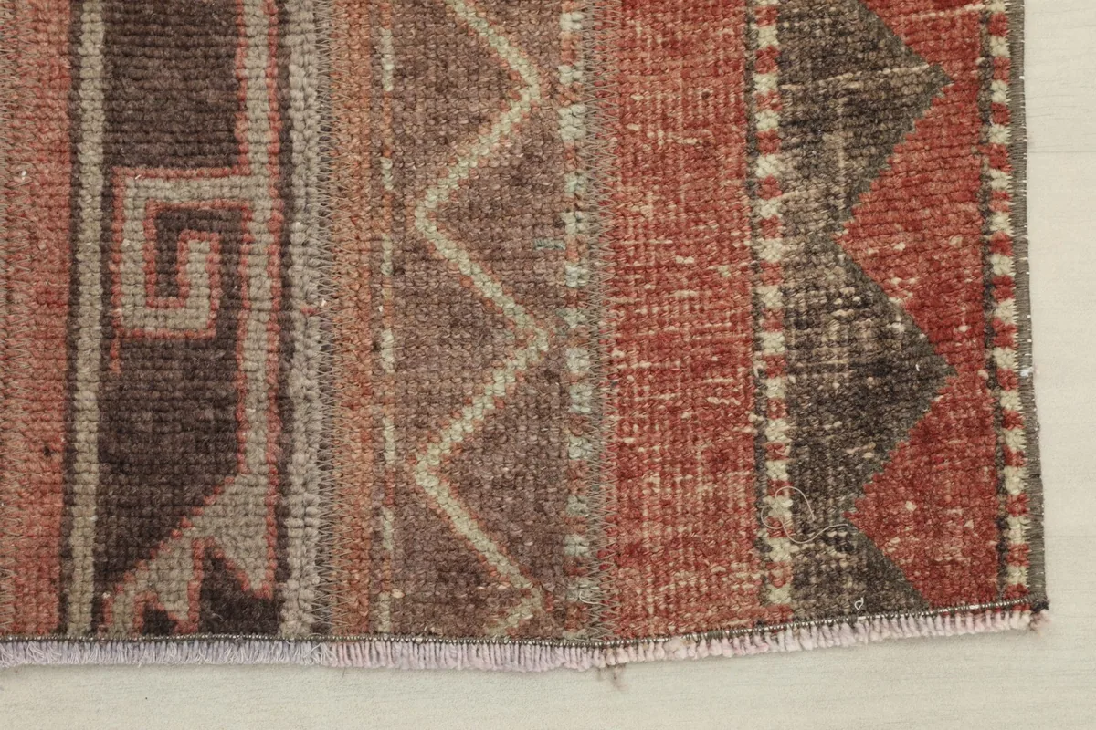 Detailed view of the rug's edge, revealing the hand-knotted wool pile and subtle color variations.