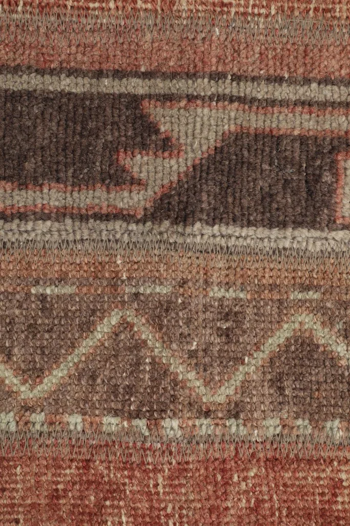 Macro detail of the rug's texture and pattern, showcasing the intricate tribal motifs and low pile.