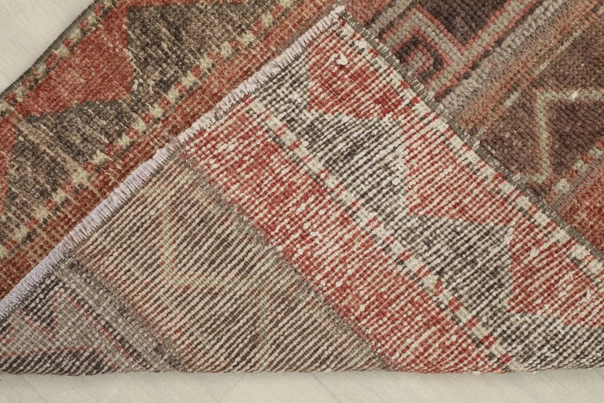 View of the back of the hand-knotted vintage wool rug, showing the cotton foundation.