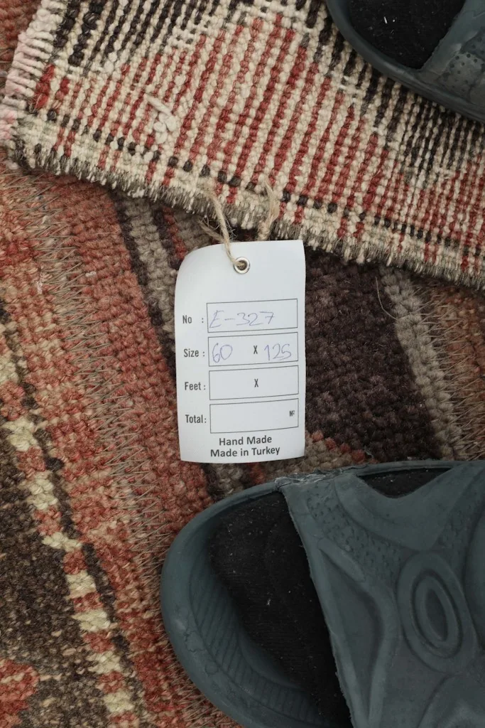 Close-up of the rug's tag, confirming its hand-made origin in Turkey and dimensions.