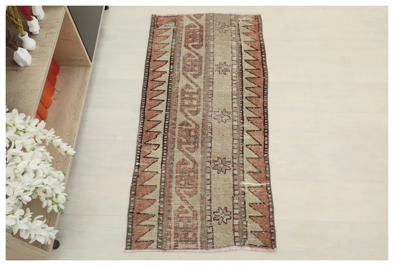 Full top view of the beige and rust tribal geometric area rug on a white background