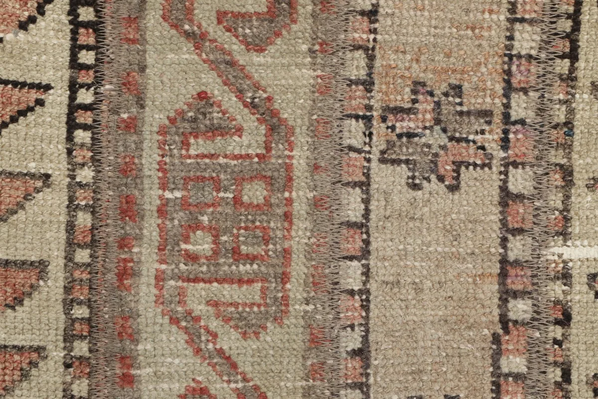Detailed view of the hand-knotted wool pile, highlighting geometric motifs and color variations