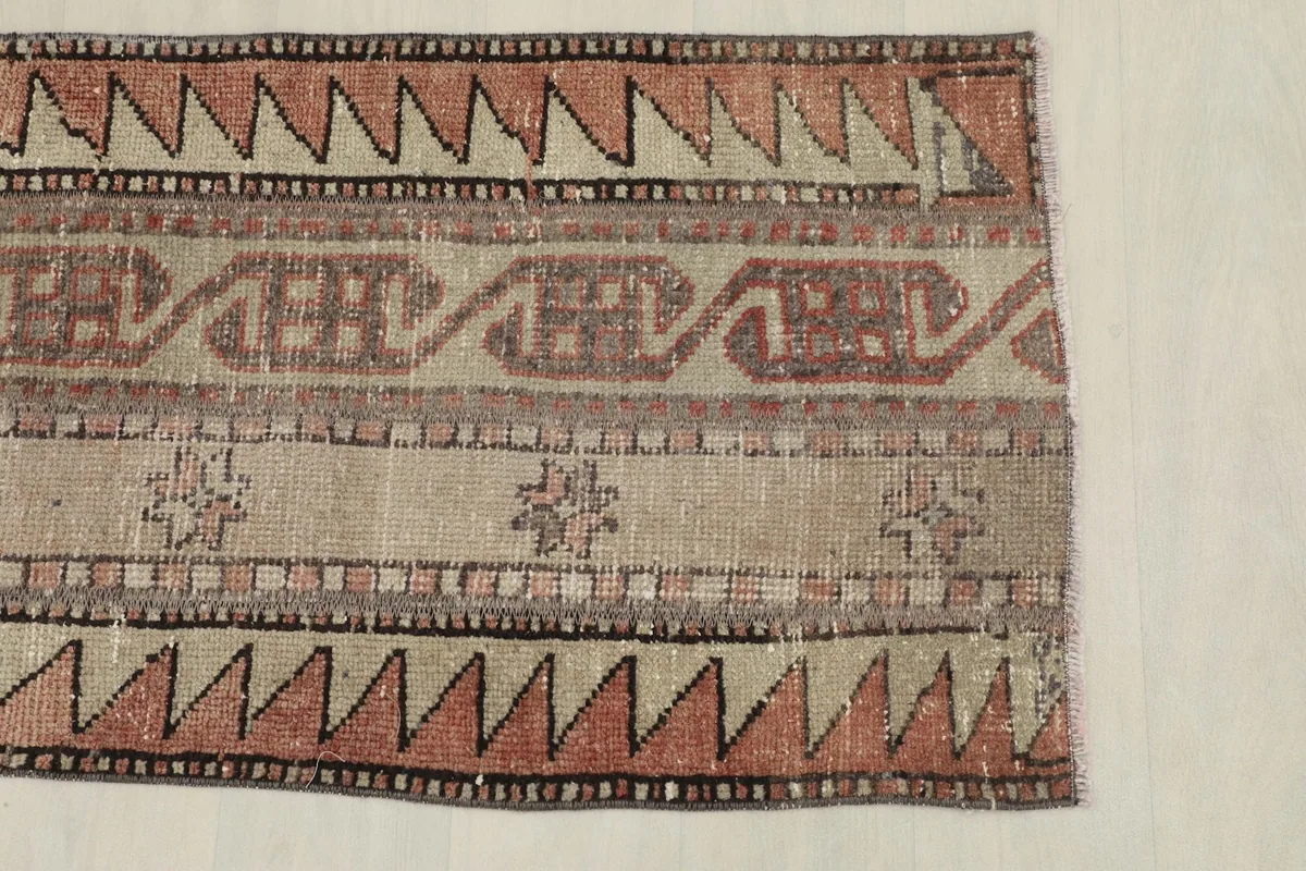 View of the rug's border and central design, showing the distinct rust and beige patterns