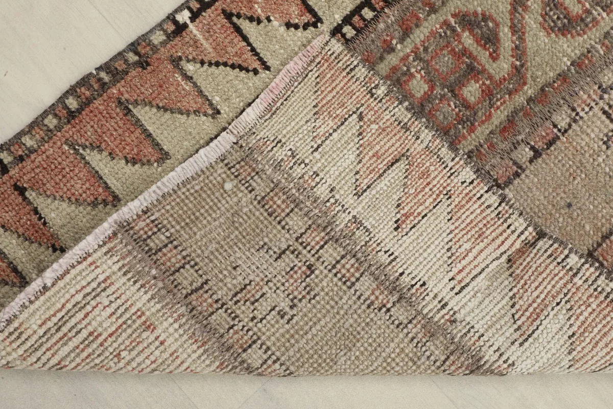 View of the rug's underside, showing the cotton foundation and hand-knotted construction