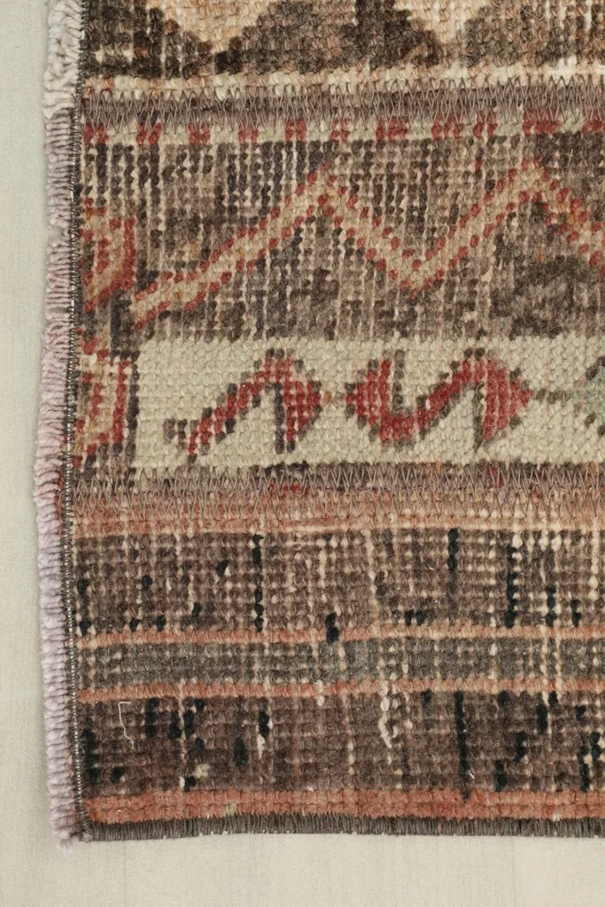 Close-up of one end of the rug, displaying the fringe and the intricate patterns.