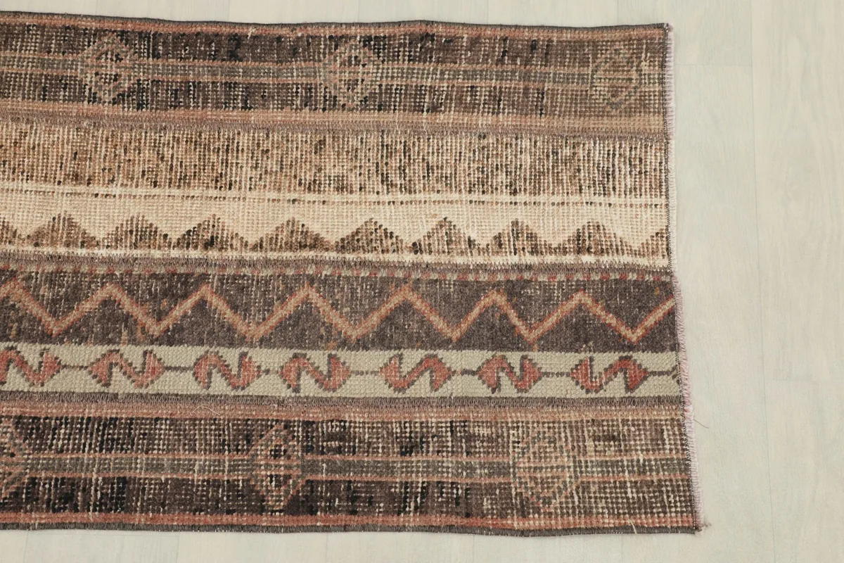 View of the rug's patterns and colors from one side, showing the distinct striped design.