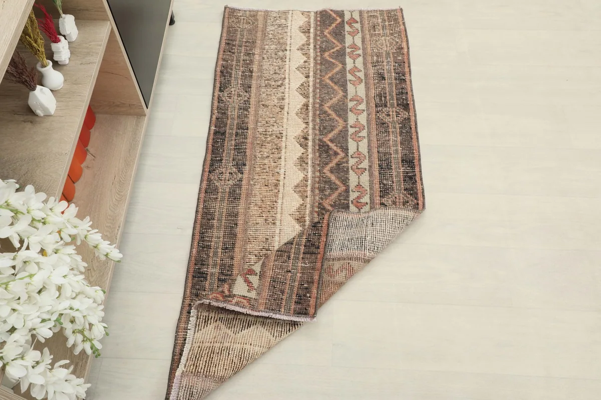 Overhead view of the rug with one corner folded back, showing the thickness and construction.
