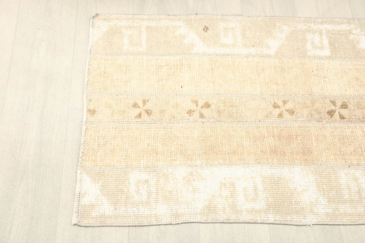 Corner view of the rug, displaying the geometric patterns and gentle wear