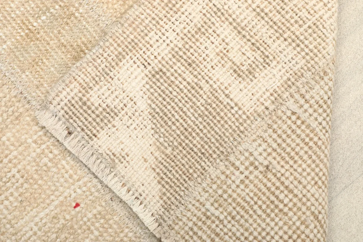 Close-up of the rug's back, revealing the cotton foundation and hand-knotted construction
