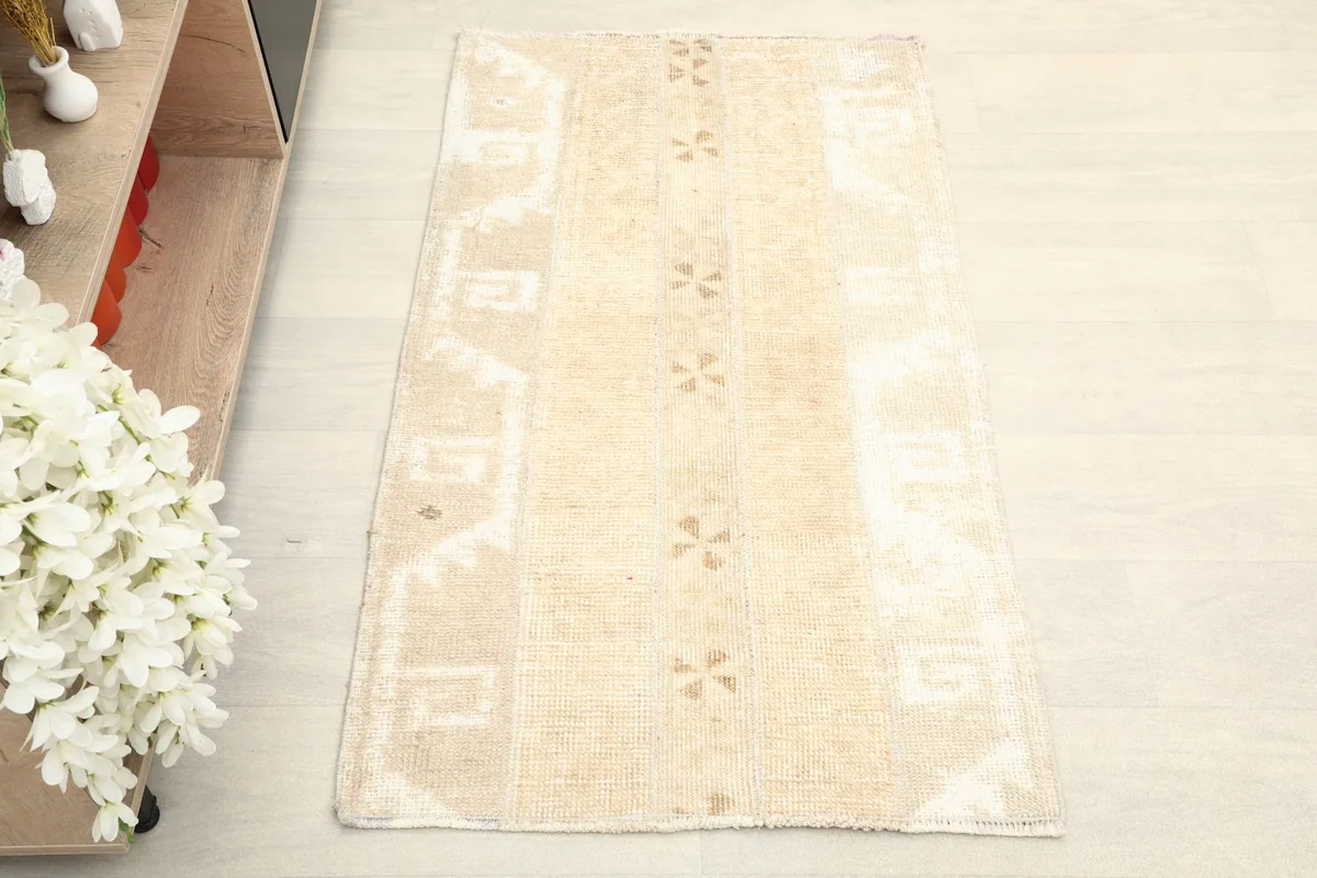 Overhead view of the beige vintage rug showcasing its geometric and tribal motifs