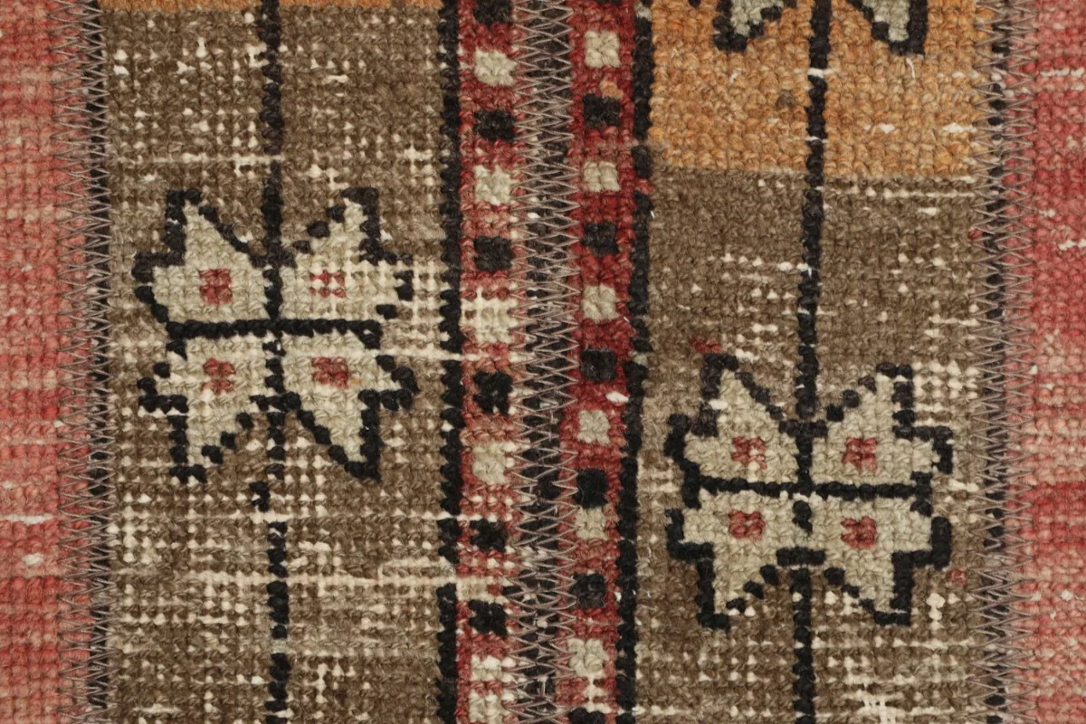 Extreme close-up of the hand-knotted wool pile showing texture and individual knots in the geometric design