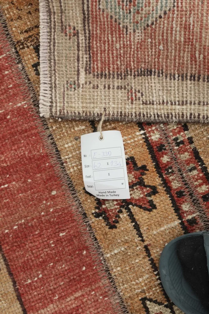 Close-up of the rug's tag, indicating hand-made origin from Turkey, next to the rug's pile