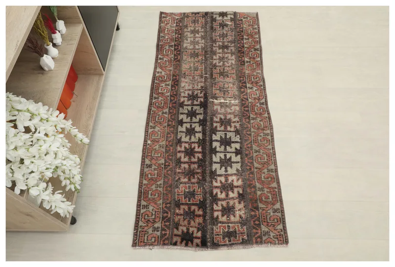 Full top view of the vintage Anatolian runner rug with charcoal, rust, and tan geometric patterns