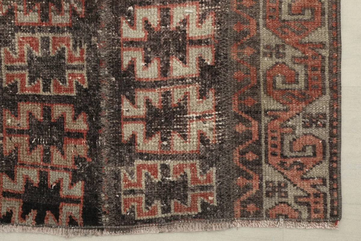 Detailed shot of the rug's border and one end, showing the intricate hand-knotted wool texture
