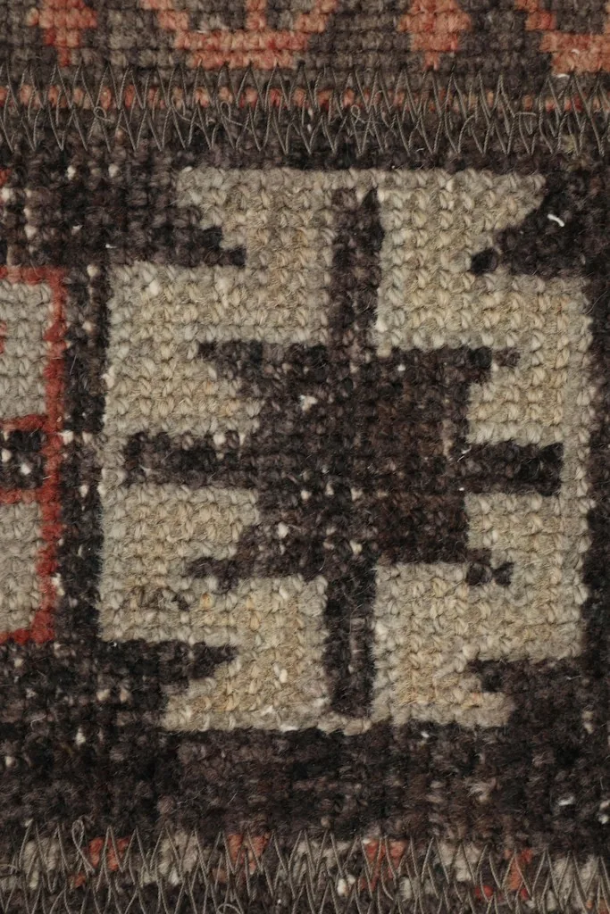 Macro view of the low wool pile and individual knots, showcasing the texture and craftsmanship