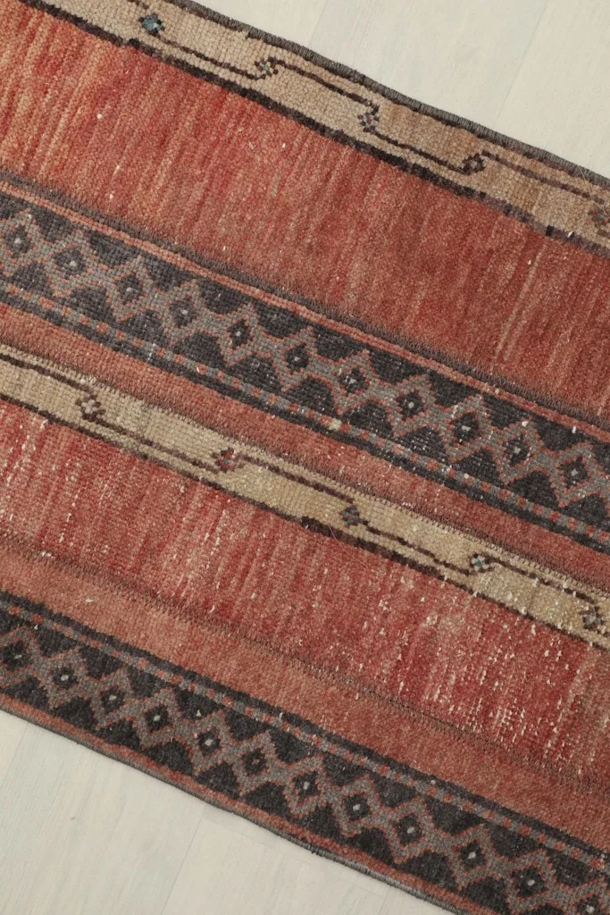 Angled view showcasing the texture and varied colors of the hand-knotted wool pile.