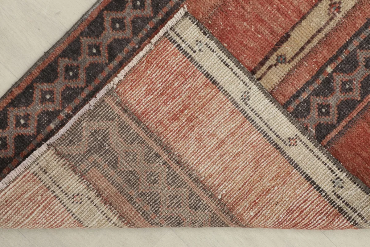 View of the back of the rug, revealing the hand-knotted construction and cotton foundation.