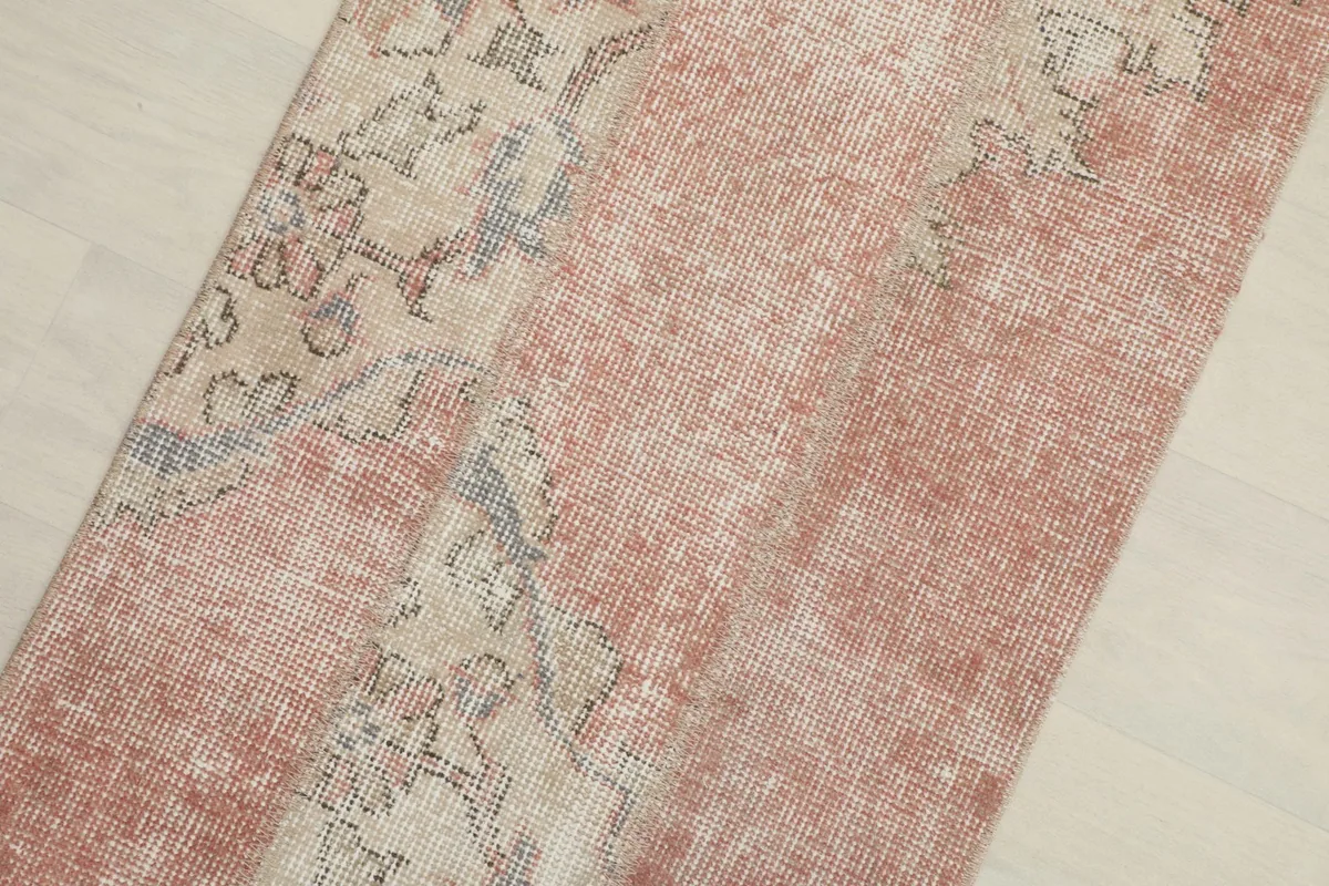 Close-up view of the vintage runner's surface, highlighting the distressed wool pile and color variations.