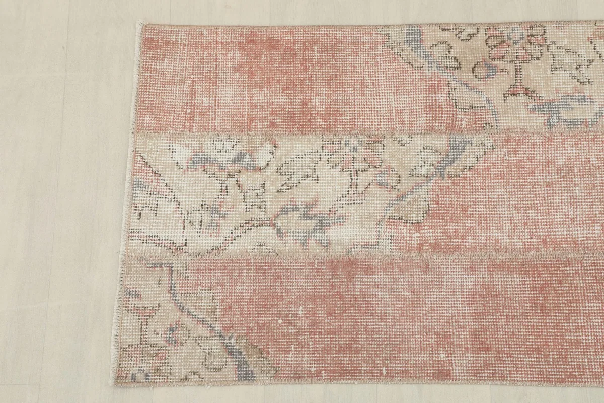 Detailed view of the lower section of the rug, showcasing the faded rose field and subtle pattern elements.