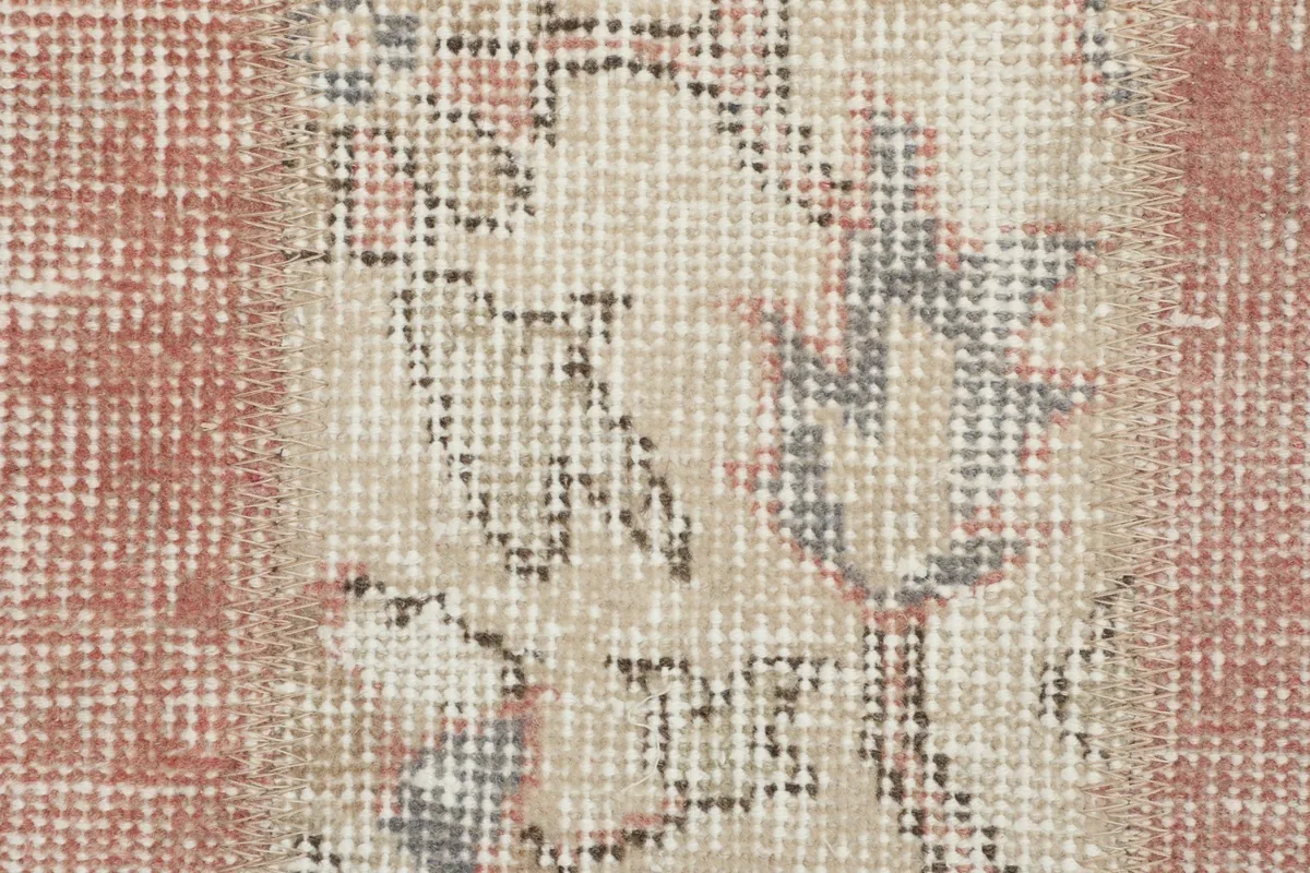Extreme close-up of the low wool pile, revealing the texture and intricate knotting of the vintage rug.