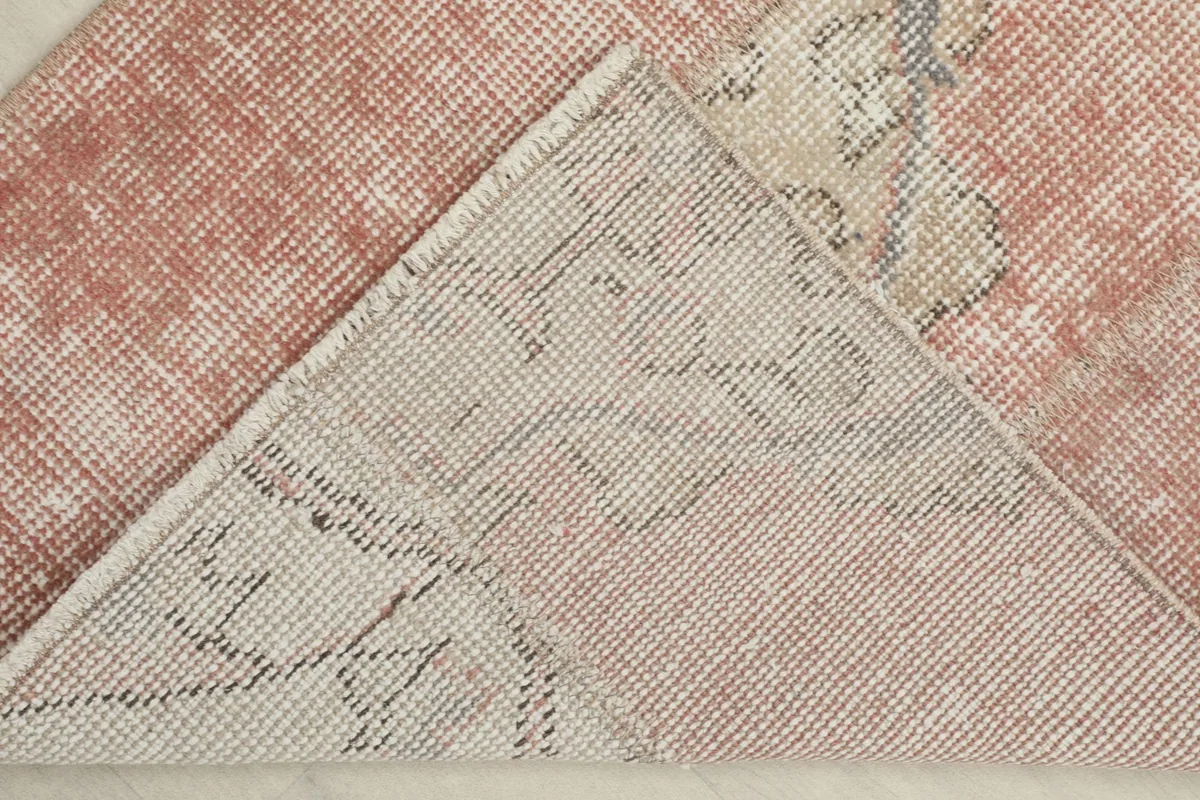 View of the back of the hand-knotted wool rug, showing the cotton foundation and knot structure.