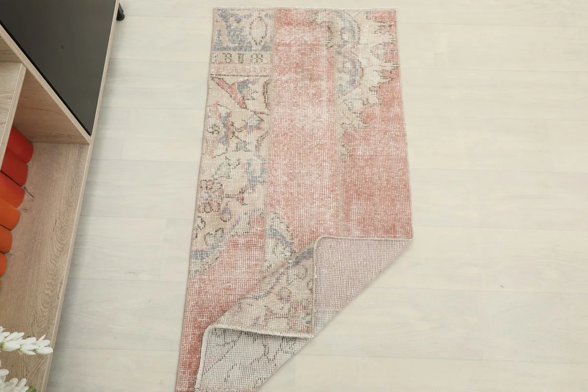 The vintage runner partially folded, displaying both the pile and the reverse side of the rug.